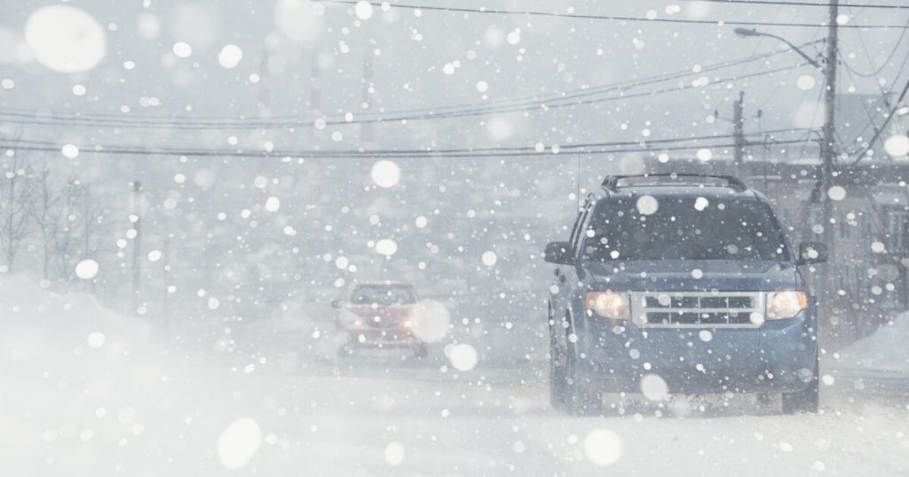 Current image: image of an SUV driving through a white-out snow storm