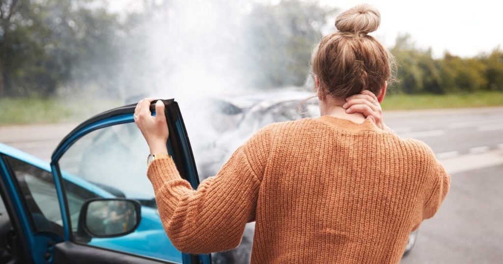 Current image: young woman injured fender bender social|woman grabbing neck right after car crash